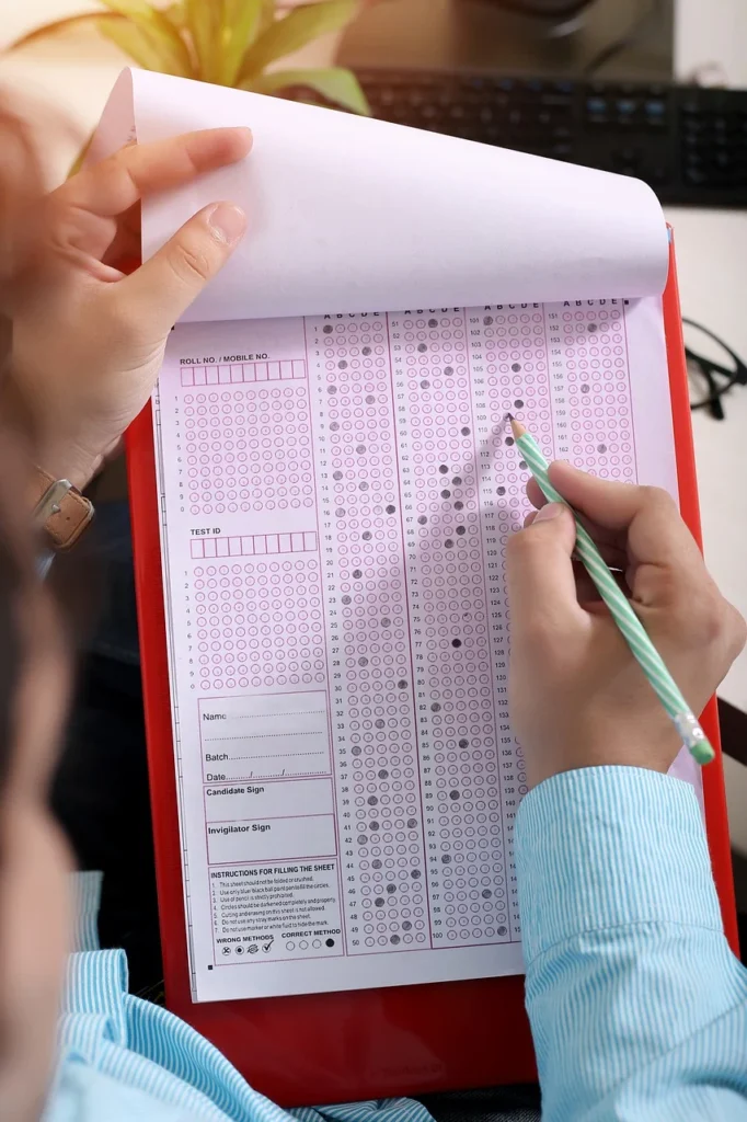 Student practicing past year papers during a competitive exam, marking answers with focus.